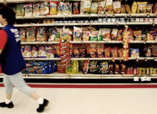 Are all ultra-processed foods equally bad for health? person walking by supermarket snack shelves