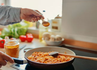 Can turmeric prevent cancer? | Nebraska Medicine Omaha, NE Hand sprinkling turmeric on pasta