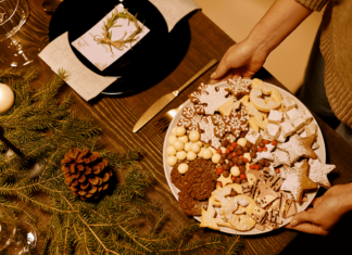 Dieting for the holidays? A registered dietitian explains how to stay healthy and on track A person placing a tray of colorful holiday cookies onto a festive table.