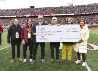 Minnesota Masonic Charities extends U of M investments to include healthy aging Three repersentatives from Minnesota Masonic Charities and three University officials pose for a photo on the field of Huntington Bank Staidum during a break in a Gopher footbal game, while all are holding an oversized printed check displaying a $35 million donation from the Masons to the U of M.