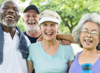 Lifestyle changes boost brain health Four older adults stand outdoors smiling and laughing together after exercise, dressed in casual athletic clothing.