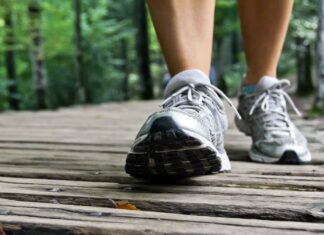 experts say hitting a certain “golden step” count each day could slow how fast your brain ages An older adult taking a healthy daily walk in a park, representing exercise benefits for cognitive health.
